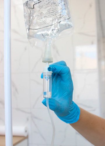 Врач поправляет капельницу